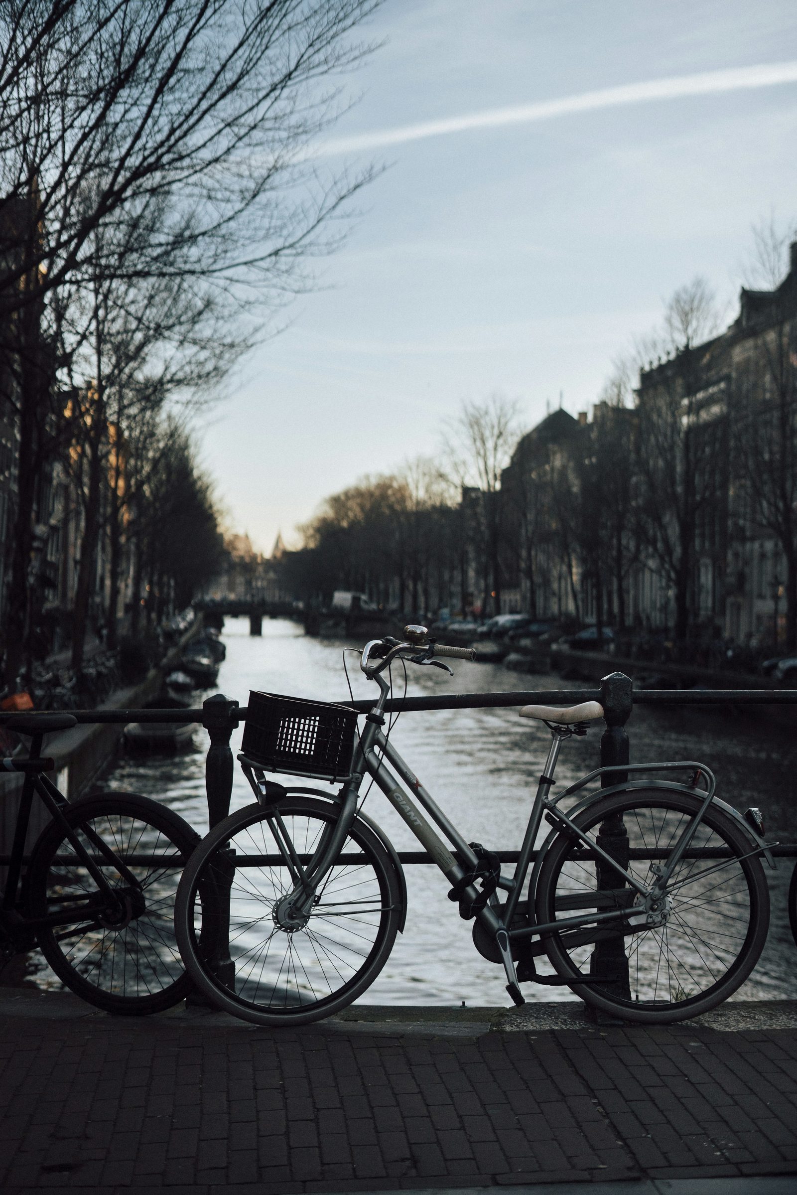 A bicycle parked at an Amsterdam canal at sunset