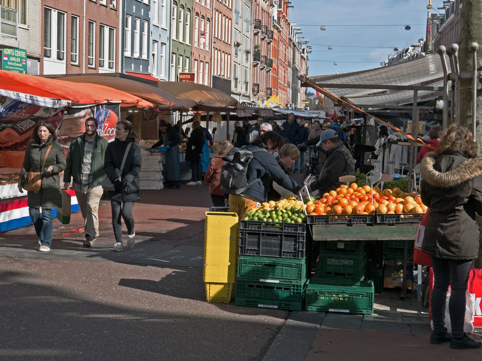A fruit stall at the Albert Cuyp market with crowds in the sun