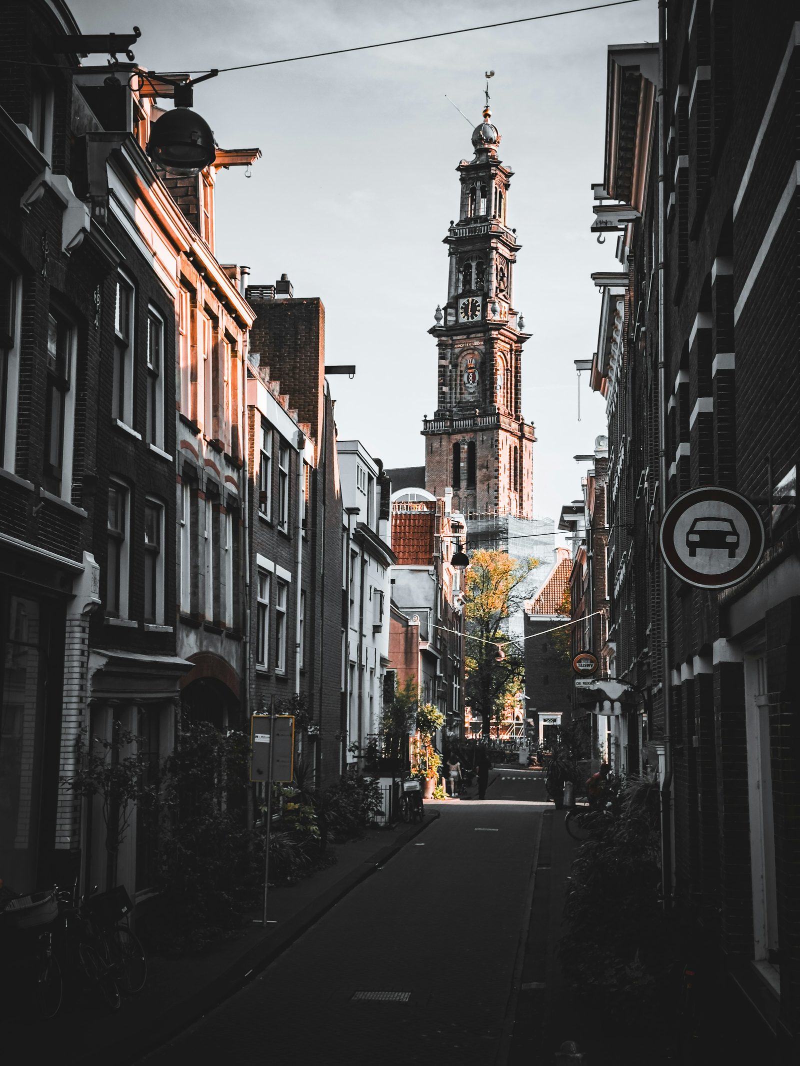 A narrow Jordaan street with the Westerkerk steeple in the distance