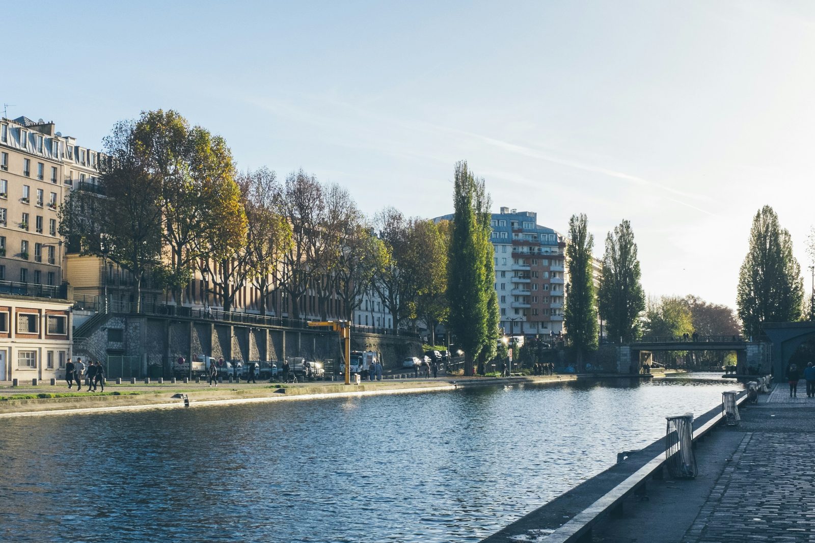 People walking along the Canal Saint-Martin under trees